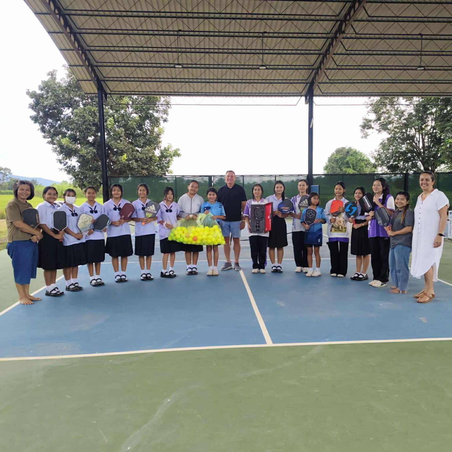 Dan from Pickleball Chiang Mai presenting balls and paddles to GTP at Jasmine Farm